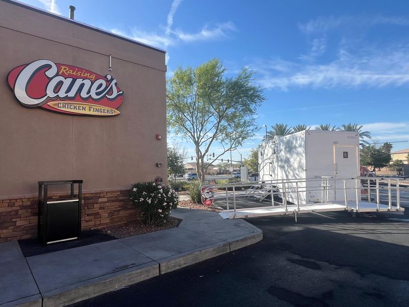 ADA restroom trailer with a wheelchair ramp and handrails