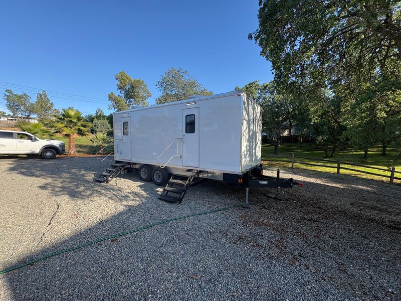 Restroom trailer parked on a gravel jobsite lot